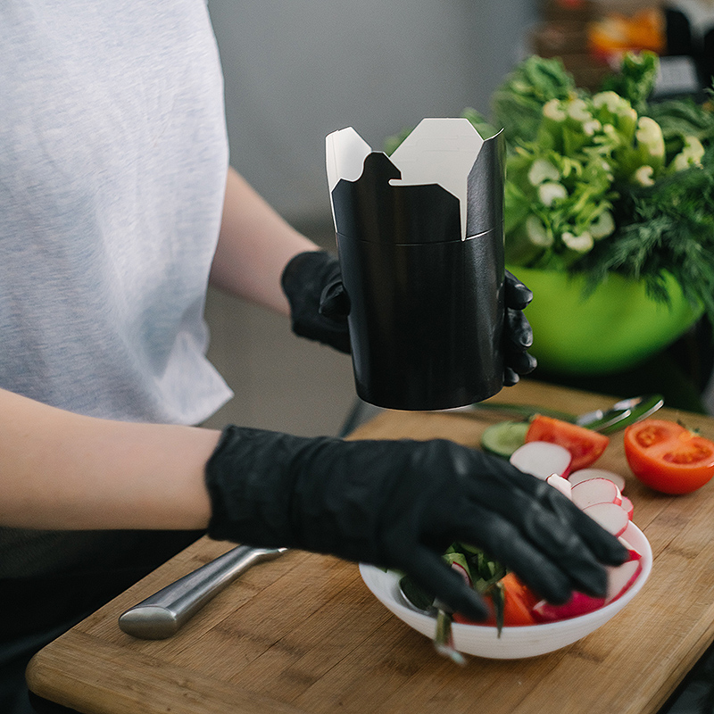 A restaurant worker wears black nitrile gloves to prepare a salad. Photo by Mikhail Nilov/Pexels