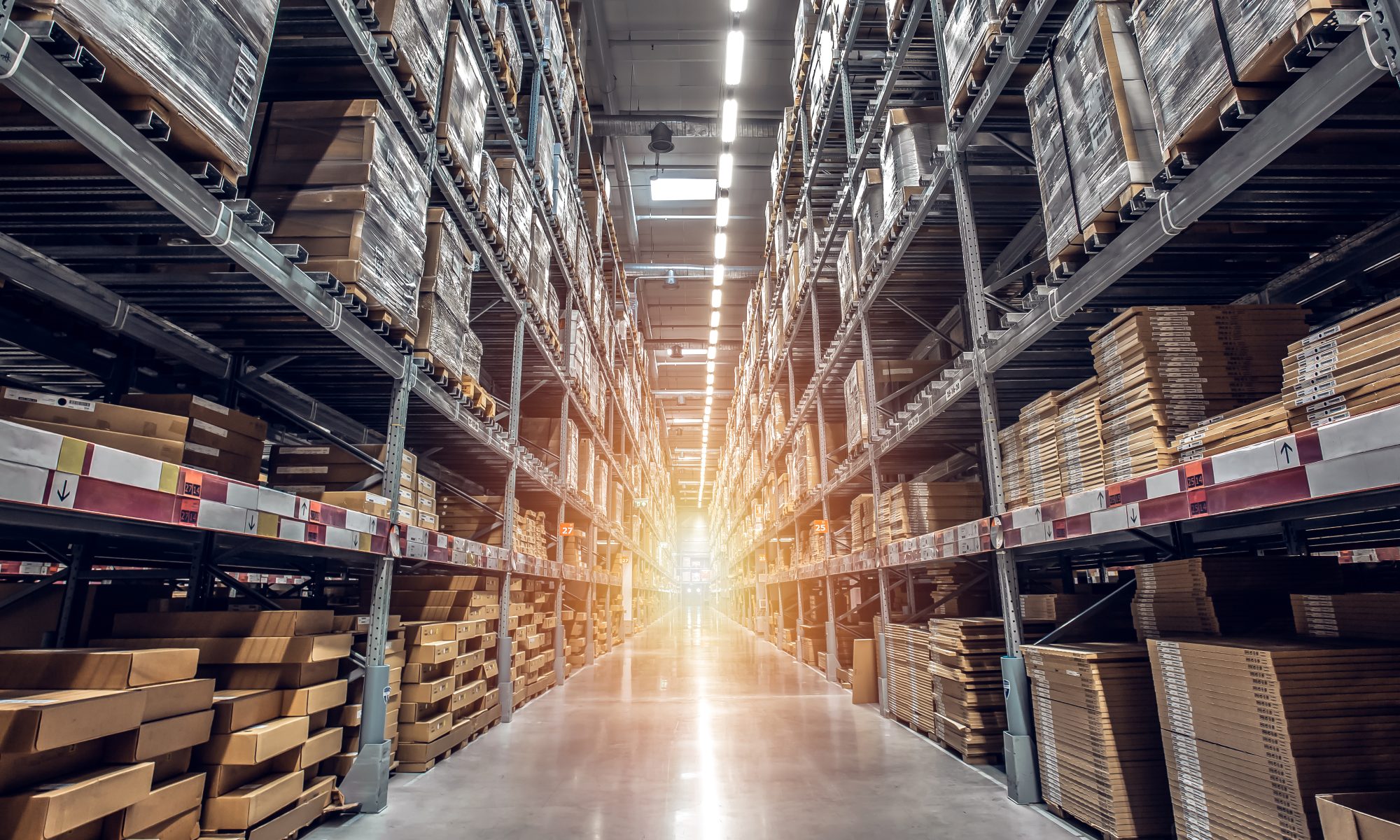 A photo captures a long shot of a warehouse with light pouring in.